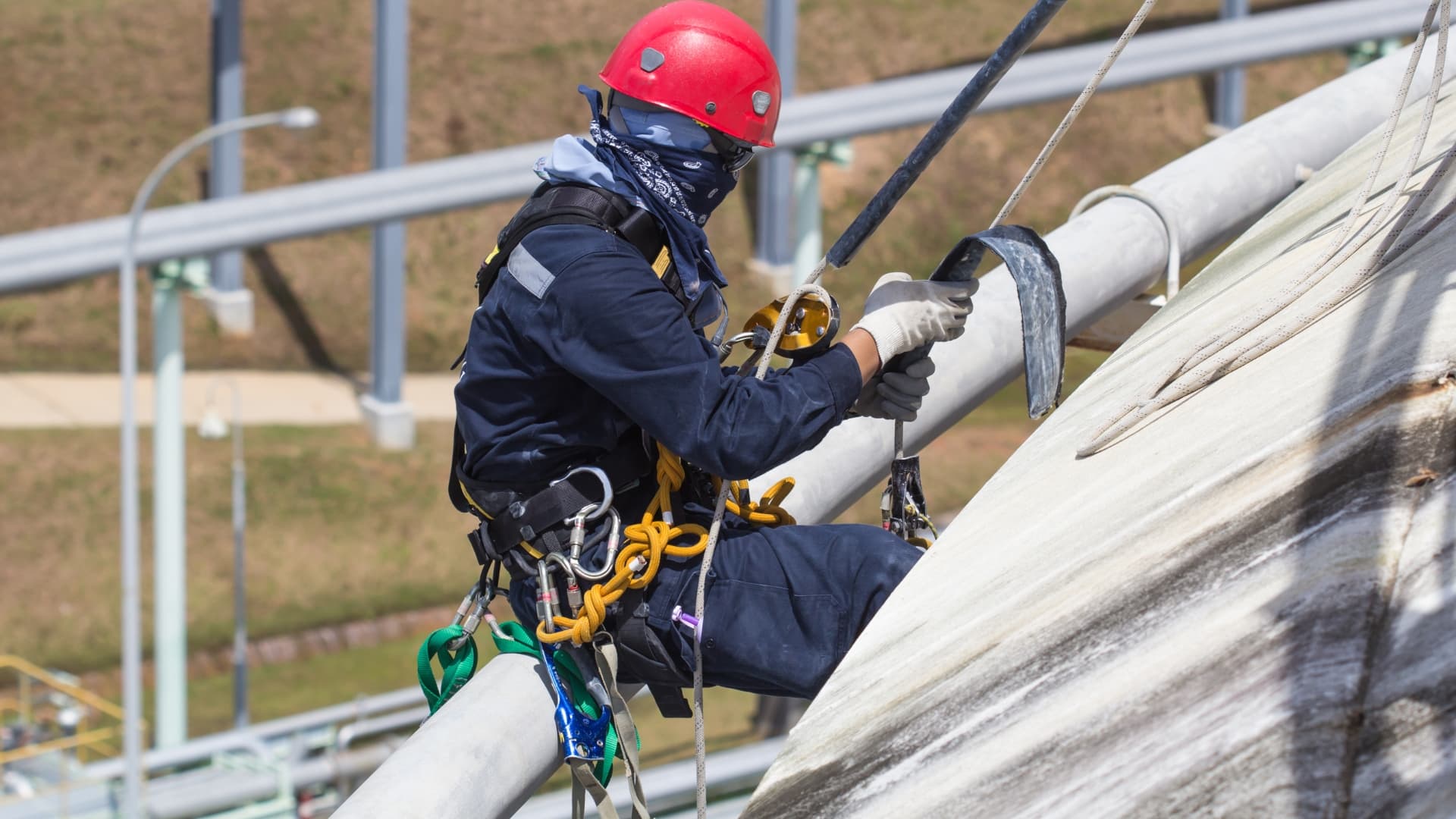 Rope access technician on an industrial structure